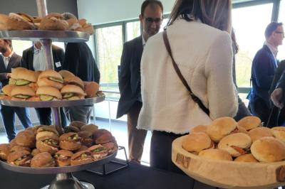 Quatre voitures sportives colorées alignées sur un parking en plein air, entourées de verdure.