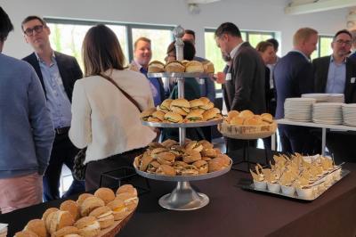 Quatre voitures sportives colorées alignées sur un parking en plein air, entourées de verdure.