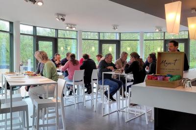 Quatre voitures sportives colorées alignées sur un parking en plein air, entourées de verdure.