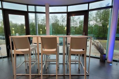 Quatre voitures sportives colorées alignées sur un parking en plein air, entourées de verdure.