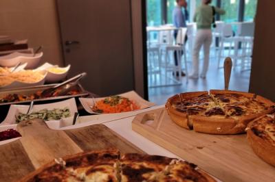 Quatre voitures sportives colorées alignées sur un parking en plein air, entourées de verdure.