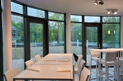 Quatre voitures sportives colorées alignées sur un parking en plein air, entourées de verdure.