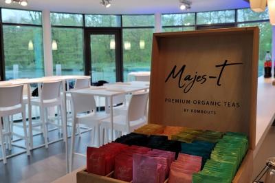 Quatre voitures sportives colorées alignées sur un parking en plein air, entourées de verdure.