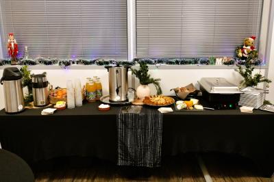 Table dressée avec des verres et un seau à champagne devant une baie vitrée, logo ’Aux Saveurs du Jour’ au mur.