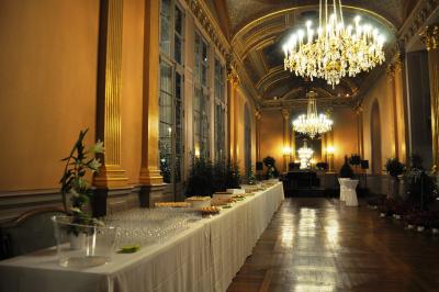 Table dressée avec des verres et un seau à champagne devant une baie vitrée, logo ’Aux Saveurs du Jour’ au mur.