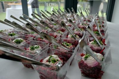 Table dressée avec des verres et un seau à champagne devant une baie vitrée, logo ’Aux Saveurs du Jour’ au mur.
