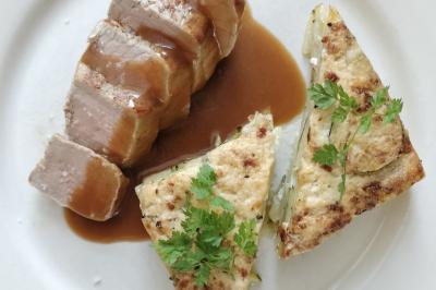 Table dressée avec des verres et un seau à champagne devant une baie vitrée, logo ’Aux Saveurs du Jour’ au mur.