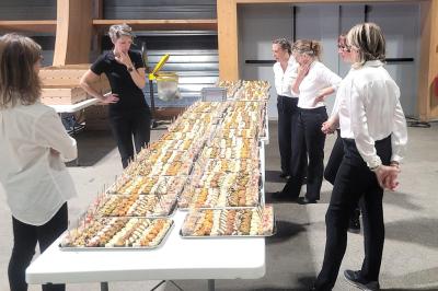 Table dressée avec des verres et un seau à champagne devant une baie vitrée, logo ’Aux Saveurs du Jour’ au mur.