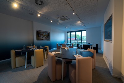 Lavabo moderne avec robinet chromé, serviettes blanches pliées et produits de toilette sur un plan en bois.