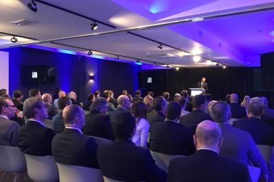 Exposition de véhicules Range Rover et Jaguar dans un showroom éclairé avec des fiches techniques visibles.