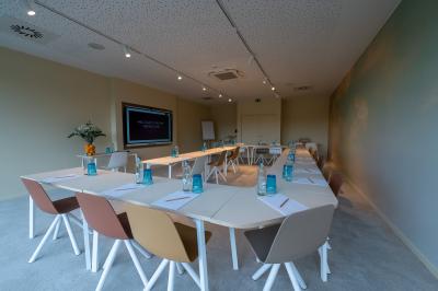 Exposition de véhicules Range Rover et Jaguar dans un showroom éclairé avec des fiches techniques visibles.