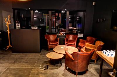 Exposition de véhicules Range Rover et Jaguar dans un showroom éclairé avec des fiches techniques visibles.