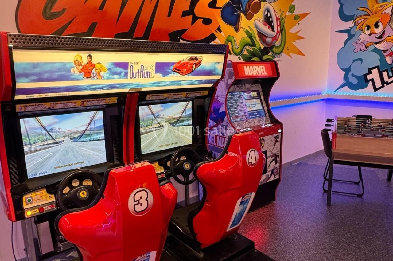 Deux bornes d'arcade rouges avec écrans, décorées par des illustrations murales colorées de personnages de jeux vidéo.