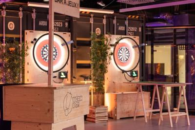Deux cibles de fléchettes lumineuses dans un espace de loisirs intérieur, avec éclairage coloré et décorations modernes.