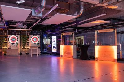 Deux cibles de fléchettes lumineuses dans un espace de loisirs intérieur, avec éclairage coloré et décorations modernes.
