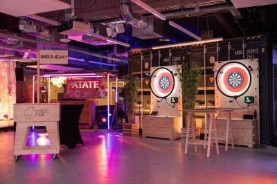 Deux cibles de fléchettes lumineuses dans un espace de loisirs intérieur, avec éclairage coloré et décorations modernes.