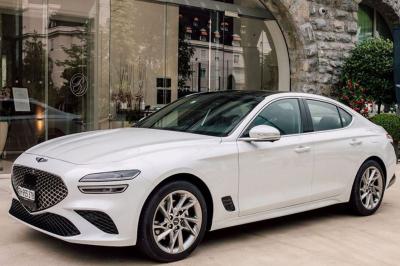 Intérieur d'une voiture avec sièges en cuir noir, écran tactile central et accoudoir avant.