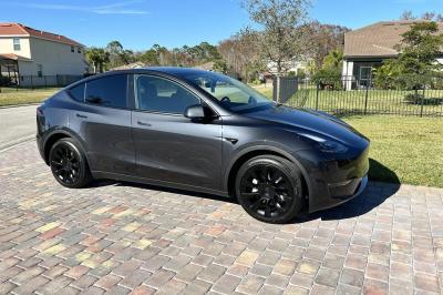 Intérieur d'une voiture avec sièges en cuir noir, écran tactile central et accoudoir avant.