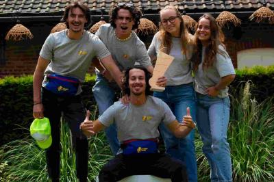 Des personnes jouent à un jeu de lancer de ballons de basket en plein air, entourées de spectateurs.