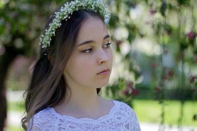 Miniature Les Créa's de Cynthia #32 Jeune femme portant une couronne de fleurs blanches, vêtue de dentelle blanche, dans un jardin verdoyant.