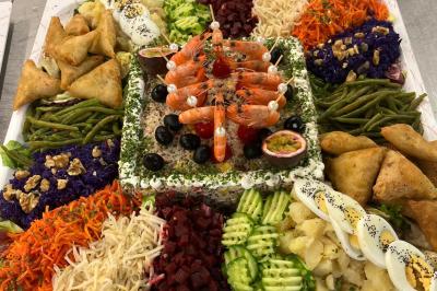 Plateau circulaire avec des pâtisseries miniatures, entouré de divers amuse-bouches et desserts sur une table.