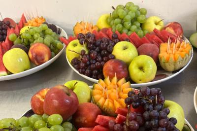 Plateau circulaire avec des pâtisseries miniatures, entouré de divers amuse-bouches et desserts sur une table.