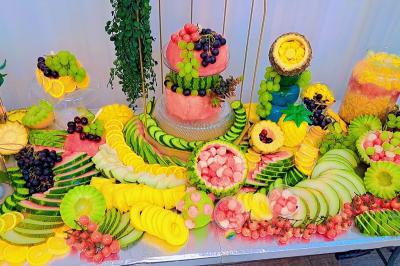 Plateau circulaire avec des pâtisseries miniatures, entouré de divers amuse-bouches et desserts sur une table.