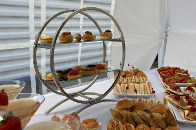 Plateau circulaire avec des pâtisseries miniatures, entouré de divers amuse-bouches et desserts sur une table.