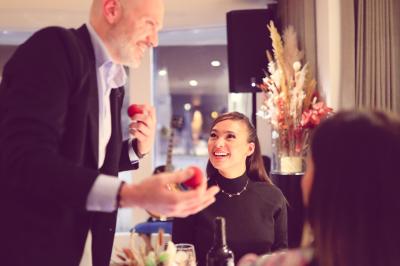 Un groupe de personnes assises et debout, riant et échangeant lors d'un moment convivial en extérieur.