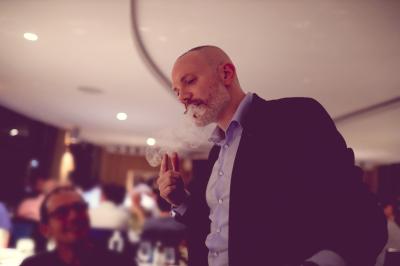Un groupe de personnes assises et debout, riant et échangeant lors d'un moment convivial en extérieur.