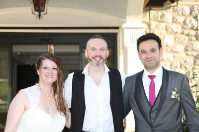Un groupe de personnes assises et debout, riant et échangeant lors d'un moment convivial en extérieur.