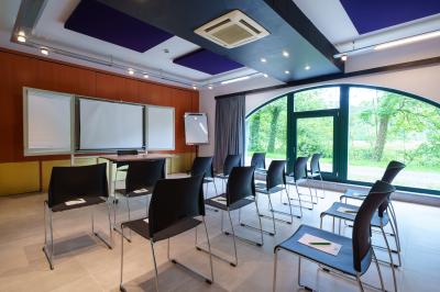 Terrasse extérieure avec tables et chaises disposées autour d’un bâtiment circulaire, vue aérienne.