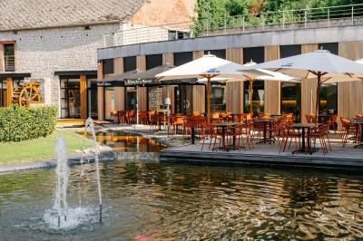 Terrasse extérieure avec tables et chaises disposées autour d’un bâtiment circulaire, vue aérienne.