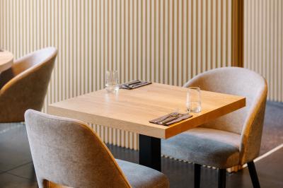 Terrasse extérieure avec tables et chaises disposées autour d’un bâtiment circulaire, vue aérienne.