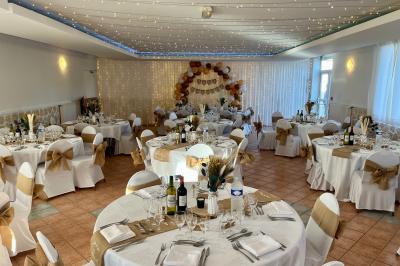 Table de tennis de table bleue en extérieur, avec deux raquettes rouges posées de part et d'autre du filet.