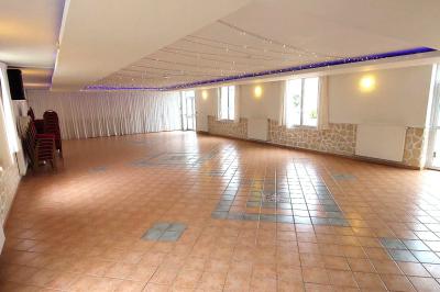 Table de tennis de table bleue en extérieur, avec deux raquettes rouges posées de part et d'autre du filet.