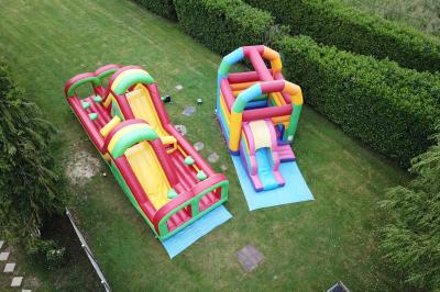 Table de tennis de table bleue en extérieur, avec deux raquettes rouges posées de part et d'autre du filet.