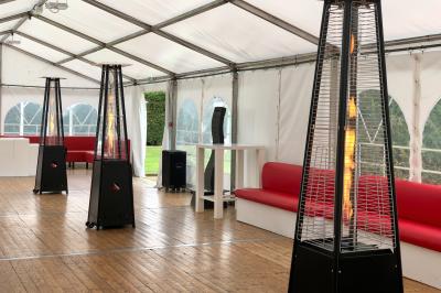 Table de tennis de table bleue en extérieur, avec deux raquettes rouges posées de part et d'autre du filet.