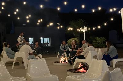 Table de tennis de table bleue en extérieur, avec deux raquettes rouges posées de part et d'autre du filet.