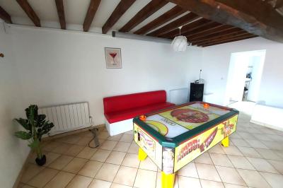 Table de tennis de table bleue en extérieur, avec deux raquettes rouges posées de part et d'autre du filet.