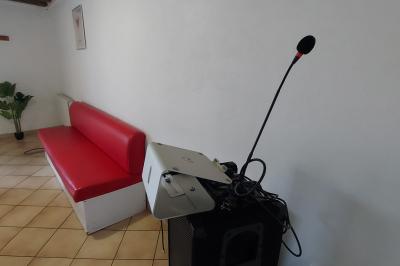 Table de tennis de table bleue en extérieur, avec deux raquettes rouges posées de part et d'autre du filet.