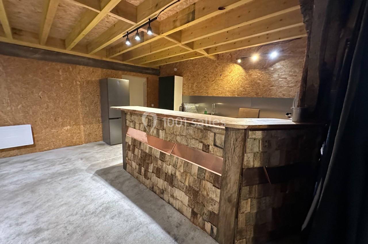 Cuisine moderne avec un comptoir en bois rustique, un réfrigérateur gris et un éclairage au plafond.