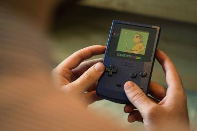 Une personne lit un manga ’Dragon Ball’ avec une couverture bleue illustrée de personnages.