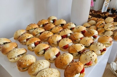 Miniature Traiteur Villefranche-sur-Saône (Rhône) - Delicesbykam #16 Buffet décoré avec des fleurs, fruits frais, verrines, mini-burgers et desserts, présenté sur une table élégante.