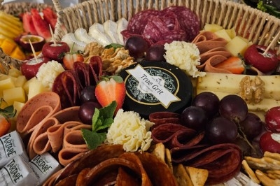 Miniature Traiteur Villefranche-sur-Saône (Rhône) - Delicesbykam #20 Buffet décoré avec des fleurs, fruits frais, verrines, mini-burgers et desserts, présenté sur une table élégante.