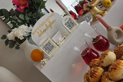 Miniature Traiteur Villefranche-sur-Saône (Rhône) - Delicesbykam #24 Buffet décoré avec des fleurs, fruits frais, verrines, mini-burgers et desserts, présenté sur une table élégante.