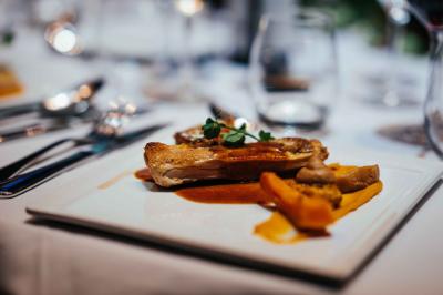 Éoliennes dans un paysage rural avec des vignes au premier plan et un ciel nuageux en arrière-plan.