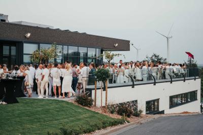 Rangées de chaises noires alignées dans une salle lumineuse avec une table en bois au premier plan.