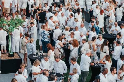 Rangées de chaises noires alignées dans une salle lumineuse avec une table en bois au premier plan.