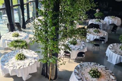 Rangées de chaises noires alignées dans une salle lumineuse avec une table en bois au premier plan.